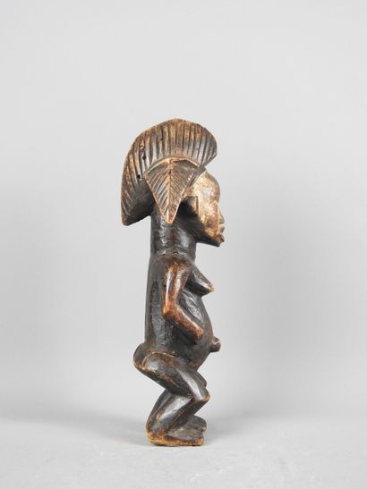Female statuette, standing with hands on...