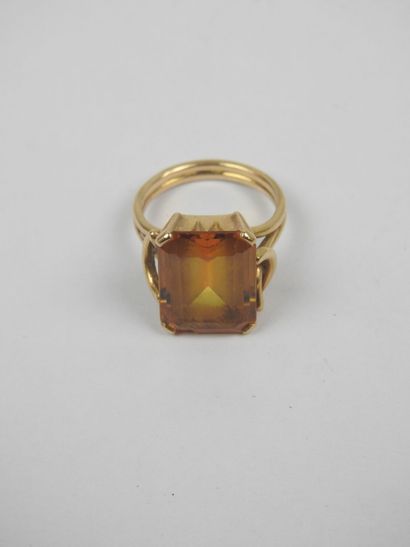 750/1000 yellow gold ring set with an emerald-cut...