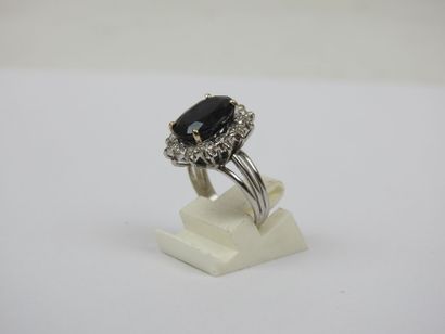 White gold ring set with a claw-set sapphire...