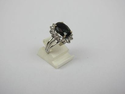White gold ring set with a claw-set sapphire...
