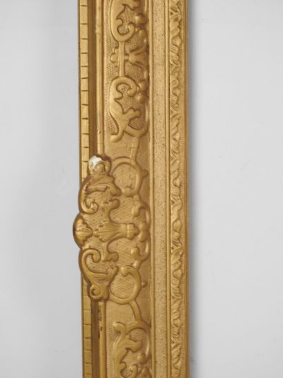 CADRE en bois et stuc doré à décor de volutes....