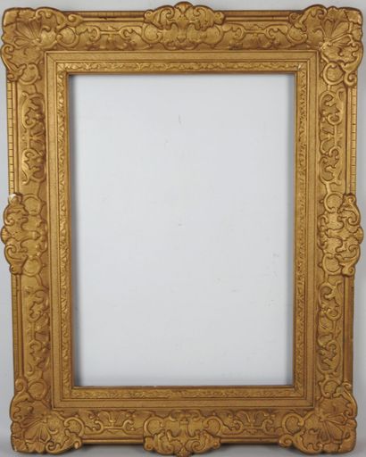 CADRE en bois et stuc doré à décor de volutes....