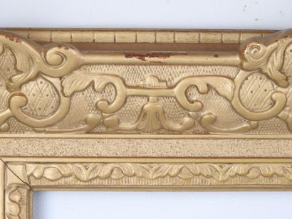 CADRE en bois et stuc doré à décor de volutes....