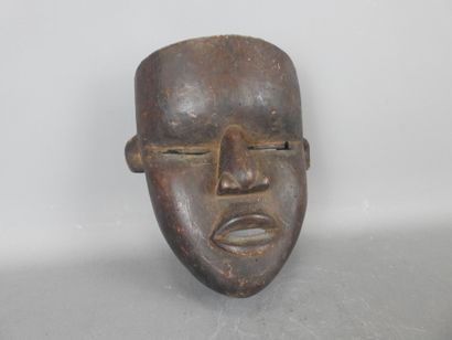 Mask with smooth face in dark patina wood....