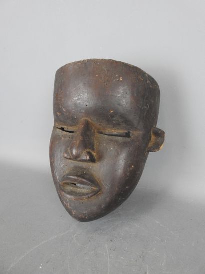 Mask with smooth face in dark patina wood....