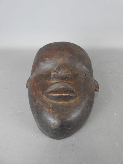 Mask with smooth face in dark patina wood....