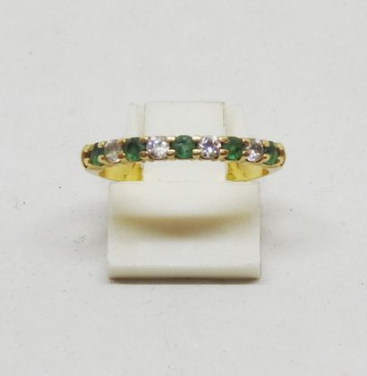 Ring set in 18K gold with alternating green...