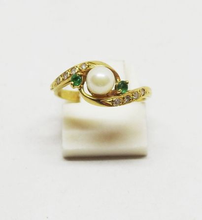 Gold ring set with a cultured pearl delicately...