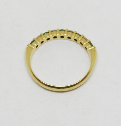 Ring set in 18K gold with alternating green...