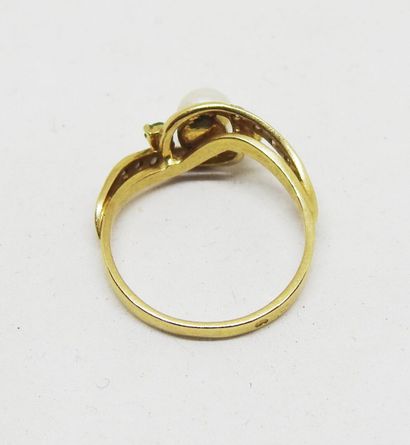 Gold ring set with a cultured pearl delicately...