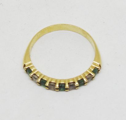 Ring set in 18K gold with alternating green...