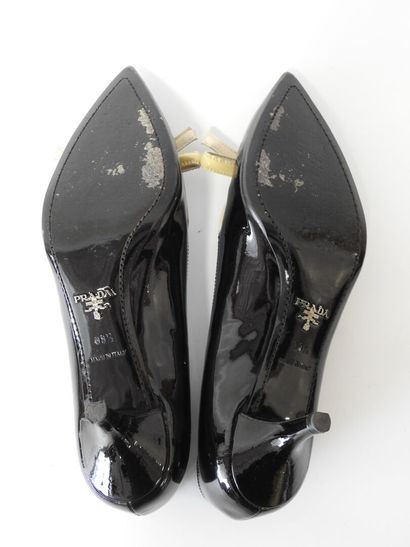 PRADA
Black patent leather pumps with cream...