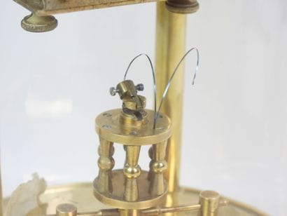 Pendule en métal doré à mouvement perpétuel...