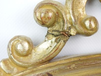 Miroir en bois argenté, fronton à décor de...