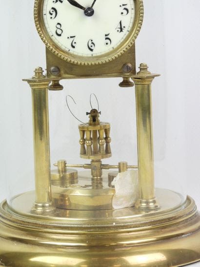 Pendule en métal doré à mouvement perpétuel...