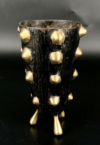 Un vase tronconique tripode en bronze patiné...