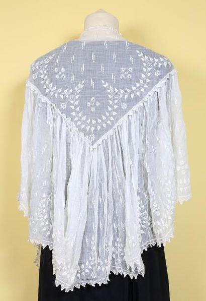 Une petite cape en linon brodé à décor de...