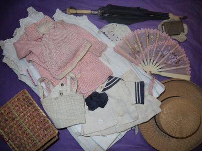 Un lot de vêtements de poupée, une ombrelle,...