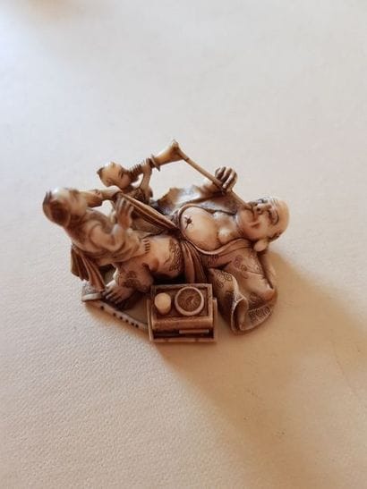 Netsuke représentant un fumeur d'opium allongé....