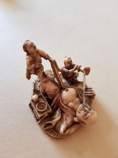 Netsuke représentant un fumeur d'opium allongé....