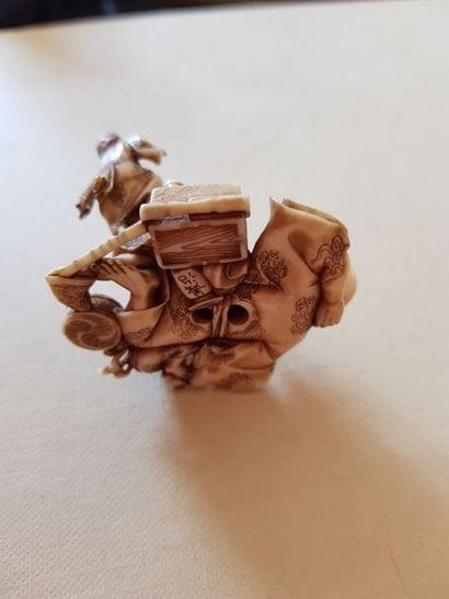 Netsuke représentant un fumeur d'opium allongé....