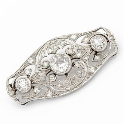 Broche en platine, plaque stylisée et ajourée...