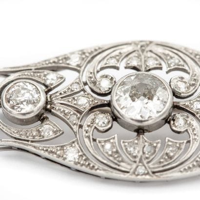 Broche en platine, plaque stylisée et ajourée...