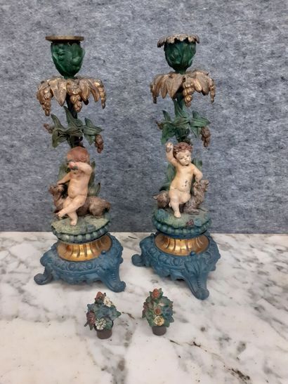 Deux candélabres à décor de putti en métal...