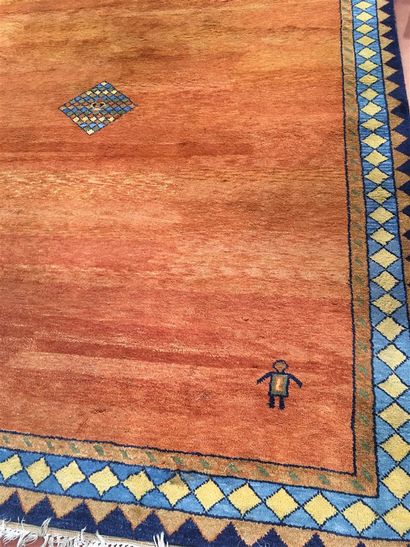 Tapis à fond orange à décor d'une bordure...
