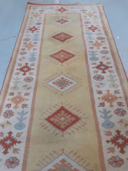 Tapis en laine à fond ocre à décor géométrique...
