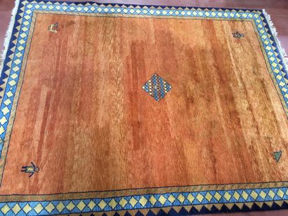 Tapis à fond orange à décor d'une bordure...