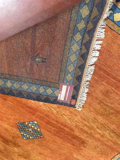 Tapis à fond orange à décor d'une bordure...