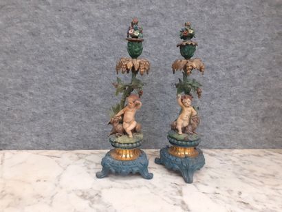 Deux candélabres à décor de putti en métal...