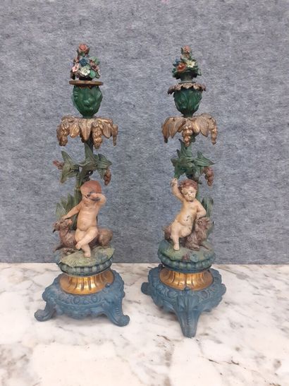 Deux candélabres à décor de putti en métal...