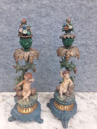 Deux candélabres à décor de putti en métal...