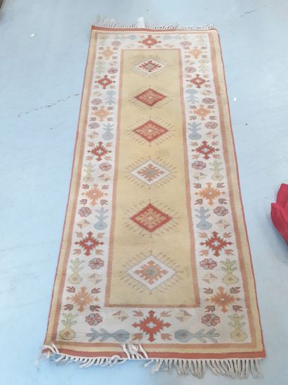 Tapis en laine à fond ocre à décor géométrique...