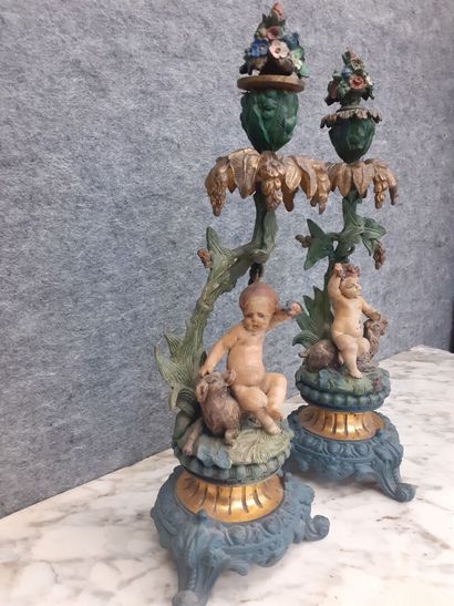 Deux candélabres à décor de putti en métal...