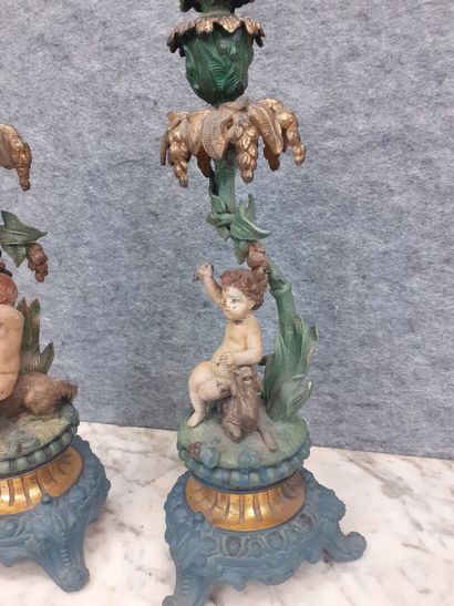 Deux candélabres à décor de putti en métal...