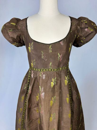 Une robe en taffetas liseré fond marron,...
