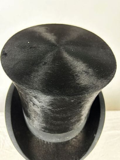 Un chapeau haut de forme taupé noir griffé...