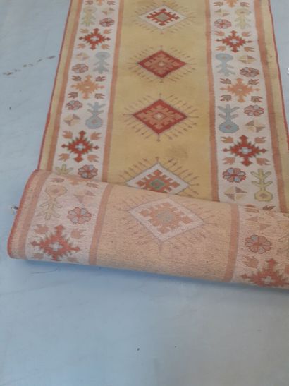 Tapis en laine à fond ocre à décor géométrique...