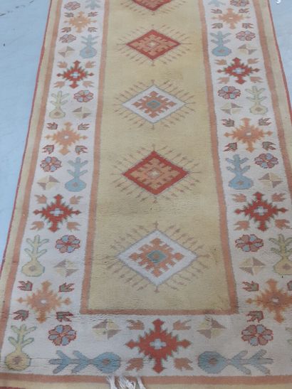 Tapis en laine à fond ocre à décor géométrique...