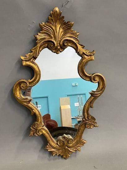 Miroir en bois doré de forme violonné à décor...