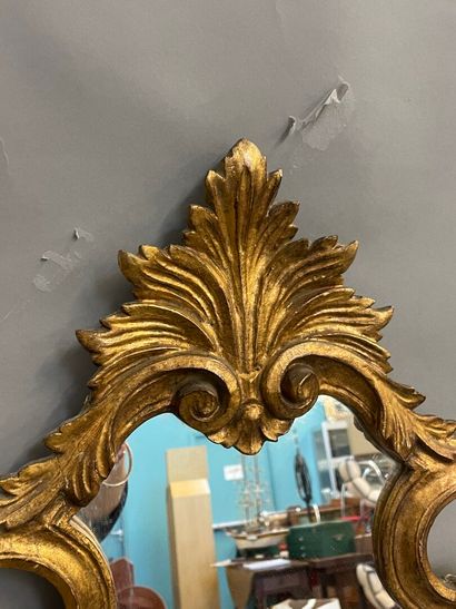 Miroir en bois doré de forme violonné à décor...