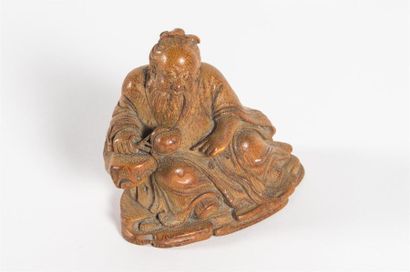Chine, sage souriant assis sur un rocher...
