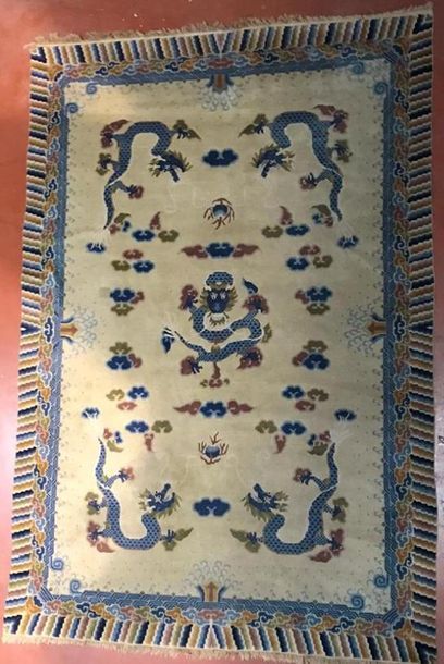 Tapis chinois fond beige à décor de dragon,...