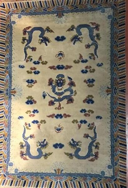 Tapis chinois fond beige à décor de dragon,...