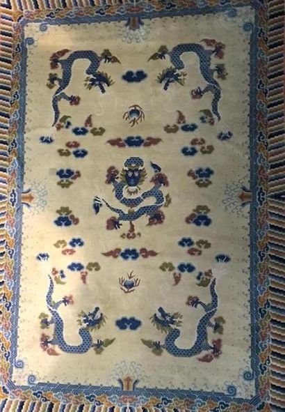 Tapis chinois fond beige à décor de dragon,...