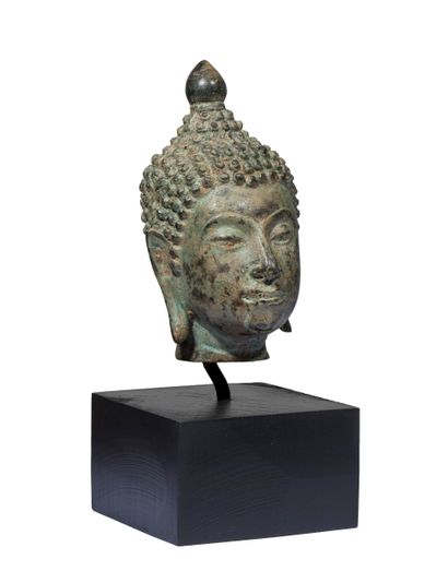 Tête de Bouddha en bronze à patine verte....