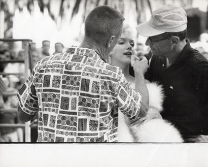 MARILYN MONROE 
Flanked by a makeup artist...